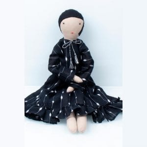 Handstitched doll in black patterned skirt and white blouse, made by women refugees from Afghanistan through Social Enterprise Silaiwali in India.