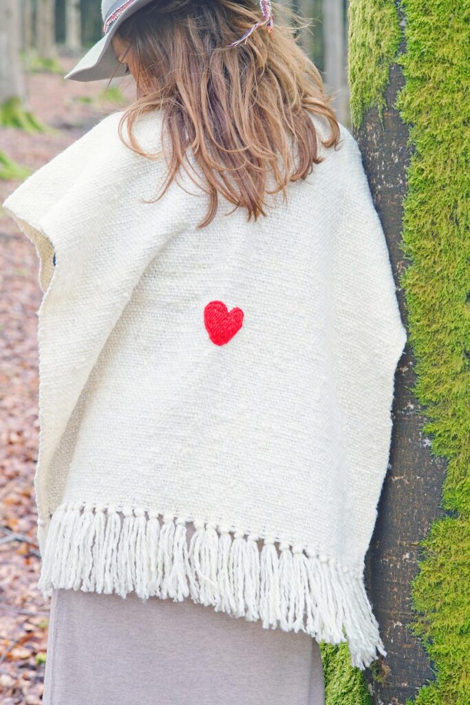 Handwoven beautiful poncho in ivory with a small read heart. Fair trade