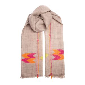 The Eastern cashmere scarf is a rose sandstone colour with vibrant pink and orange chevrons. Handwoven by local women in the Himalayas.