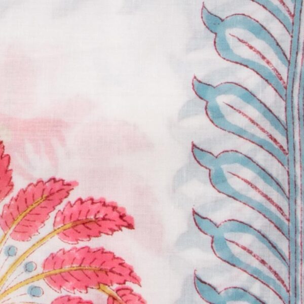 Close up detail of White sarong adorned with pink palm motifs, blue wave designs at the bottom, and subtle golden stripes.